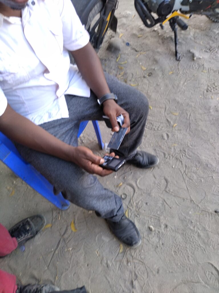 A man holding a mobile phone near the Benjamin Mkapa Stadium in Dar es Salaam, Tanzania.