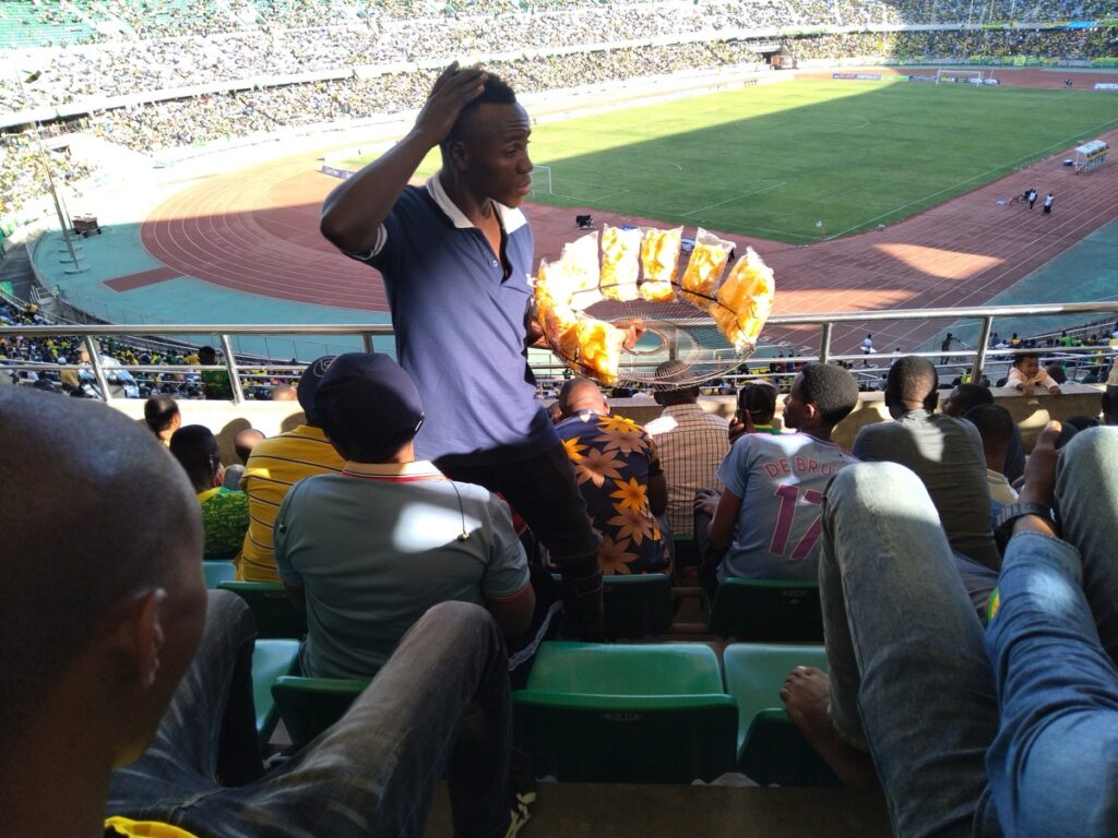 A vendor selling snacks to football fans in the stands at Benjamin Mkapa Stadium in Dar es Salaam, Tanzania.