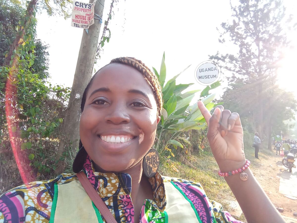 Sarah smiling and posing for a photo in front of the lush greenery at the Uganda Museum in Kampala.