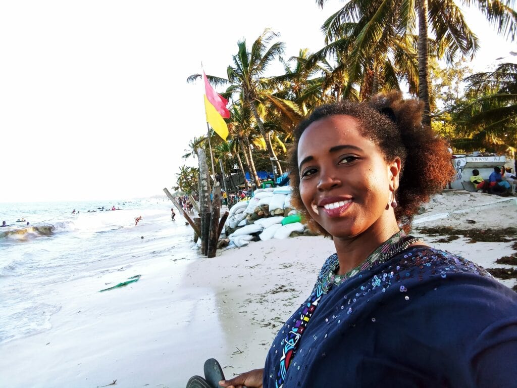 Beach scene with smiling sarah on tropical shoreline.