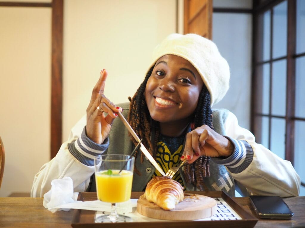 sarah eating a croissant at a cafe in osaka