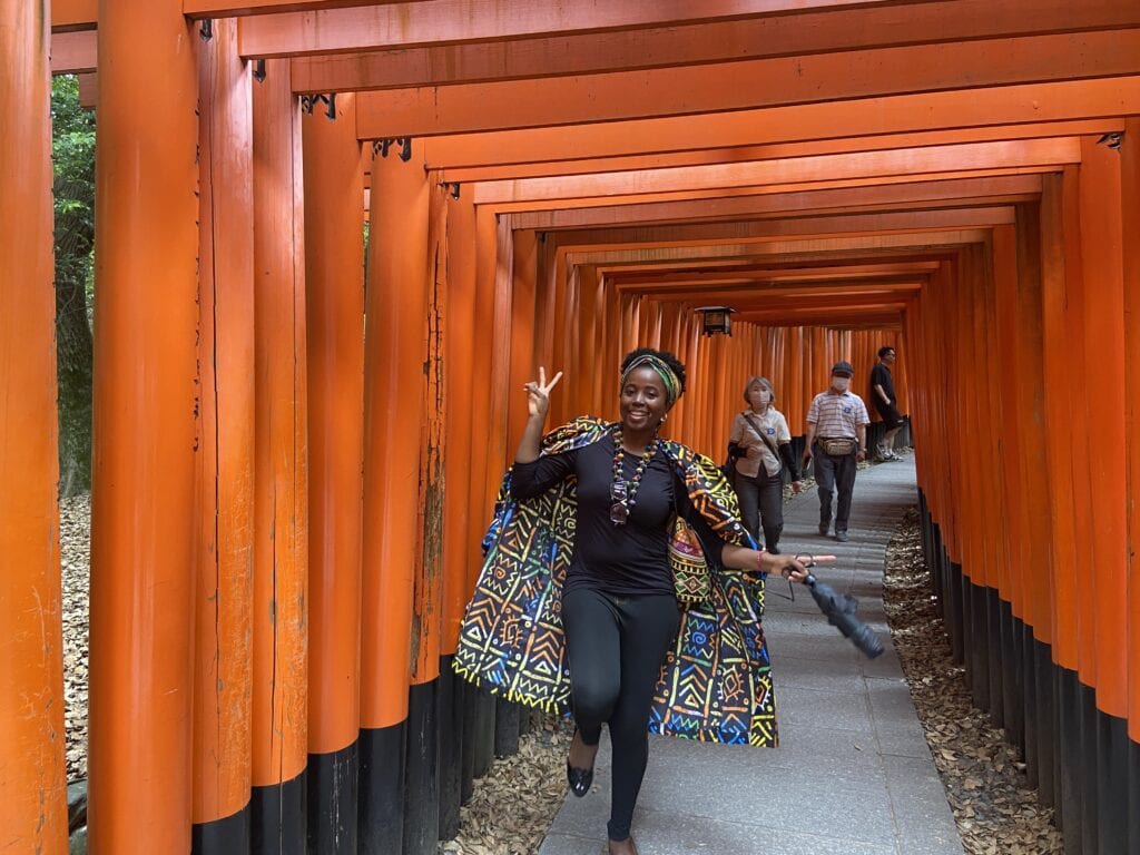 sarah enjoying walk through vibrant red torii gates in a peaceful outdoor setting in kyoto japan