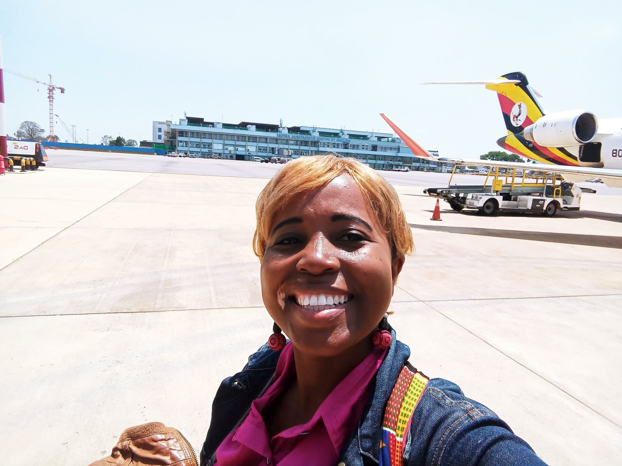 Traveling woman at airport with airplane in background.
